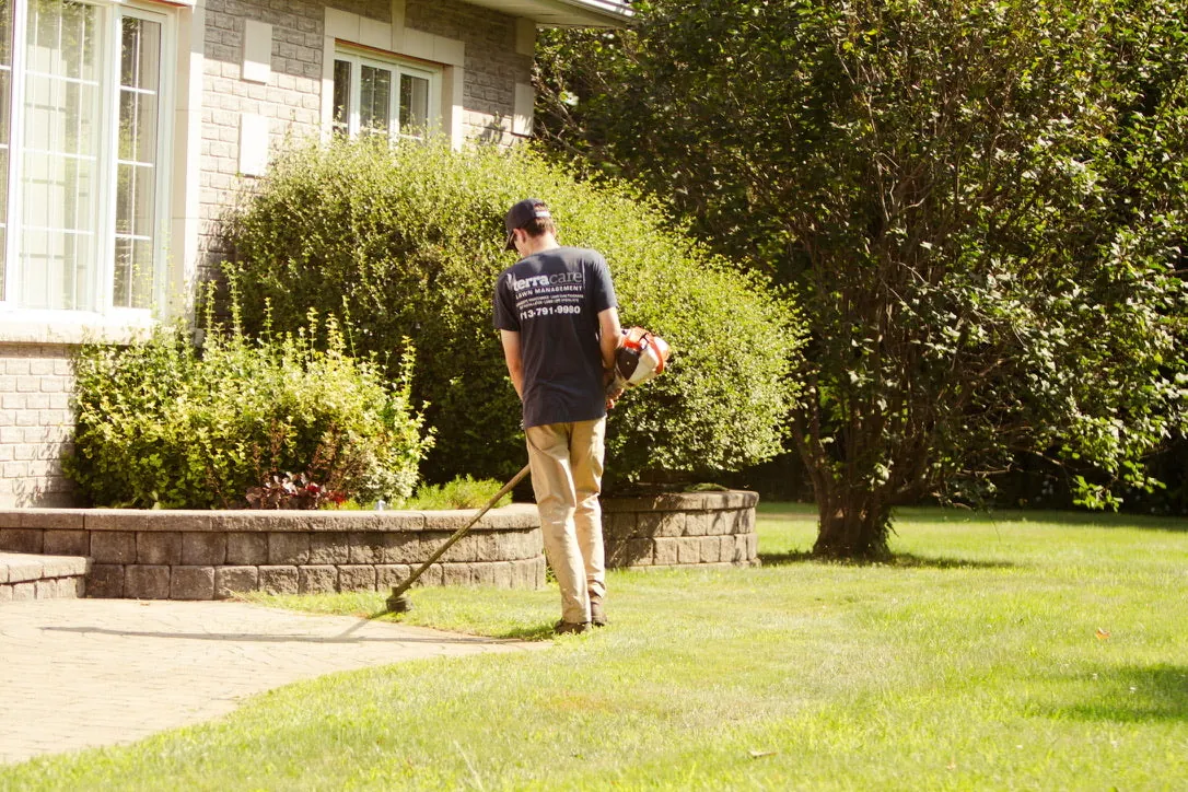 TerraCare crew member edging and trimming a lawn